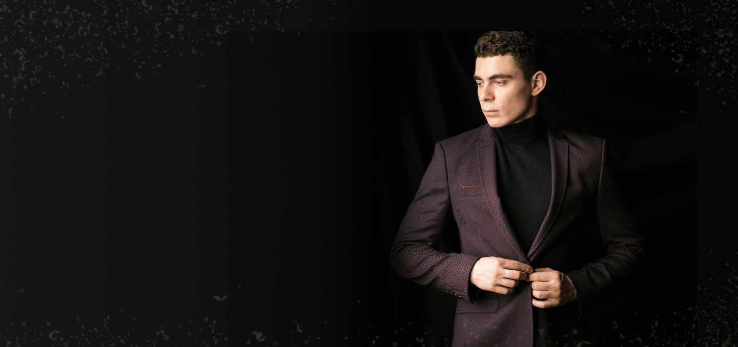 tylish man wearing a burgundy blazer with a black turtleneck against a dark background