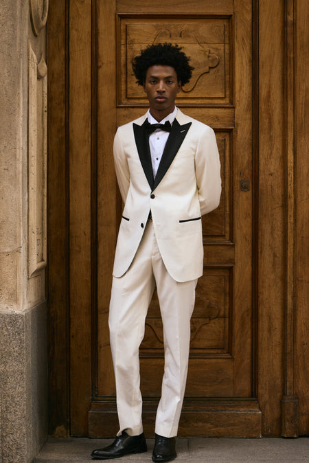 Man wearing ivory tuxedo with black lapels and bow tie formal black tie outfit