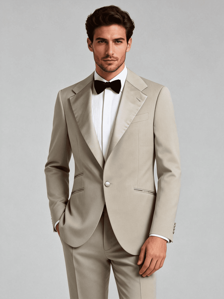 Man wearing a beige tuxedo with a black bow tie on a plain background