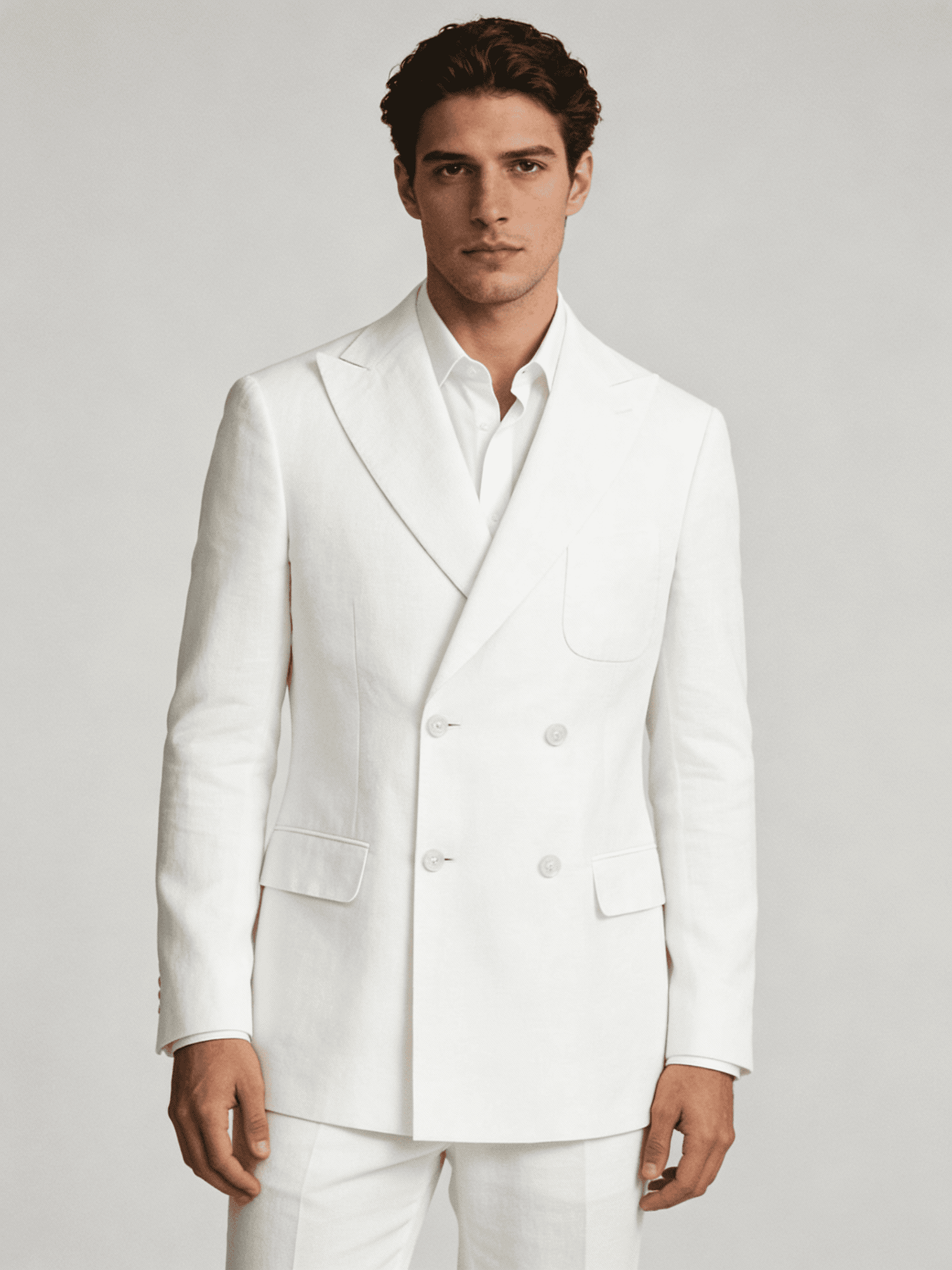 Man wearing a white suit against a plain background