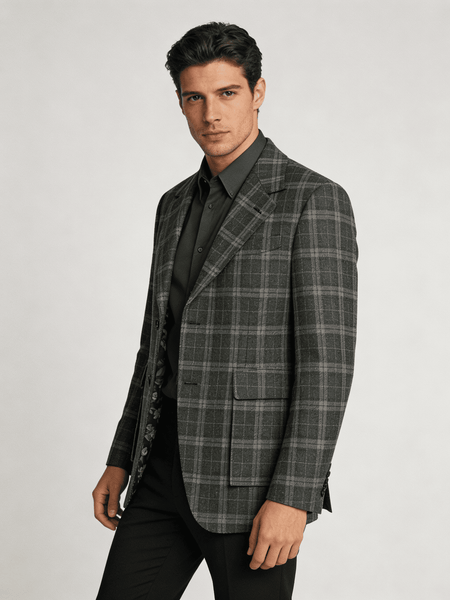 Man wearing a gray checkered blazer over a black shirt on a white background