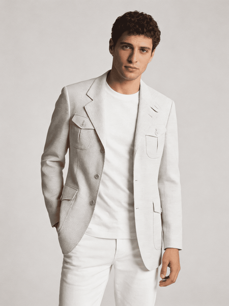 Man wearing a light gray suit and white shirt against a plain background