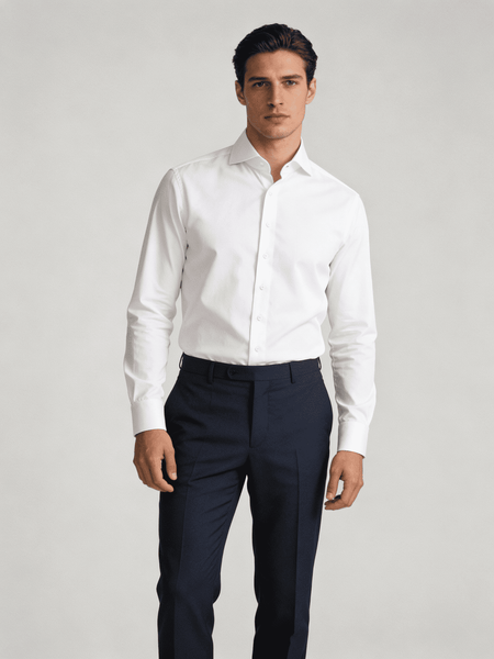 Man wearing a white dress shirt and navy pants on a light gray background