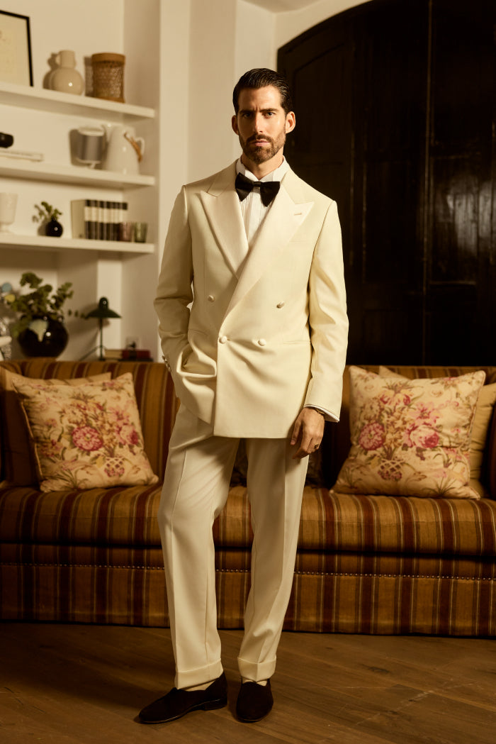 Man wearing cream double-breasted tuxedo with bow tie elegant formal outfit