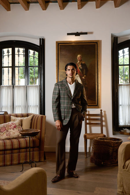 Man wearing green plaid blazer with brown trousers elegant smart casual outfit indoors