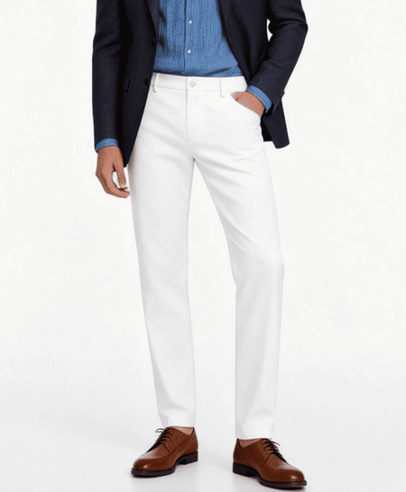 Men’s white tailored trousers styled with blue shirt, navy blazer and brown shoes smart casual outfit
